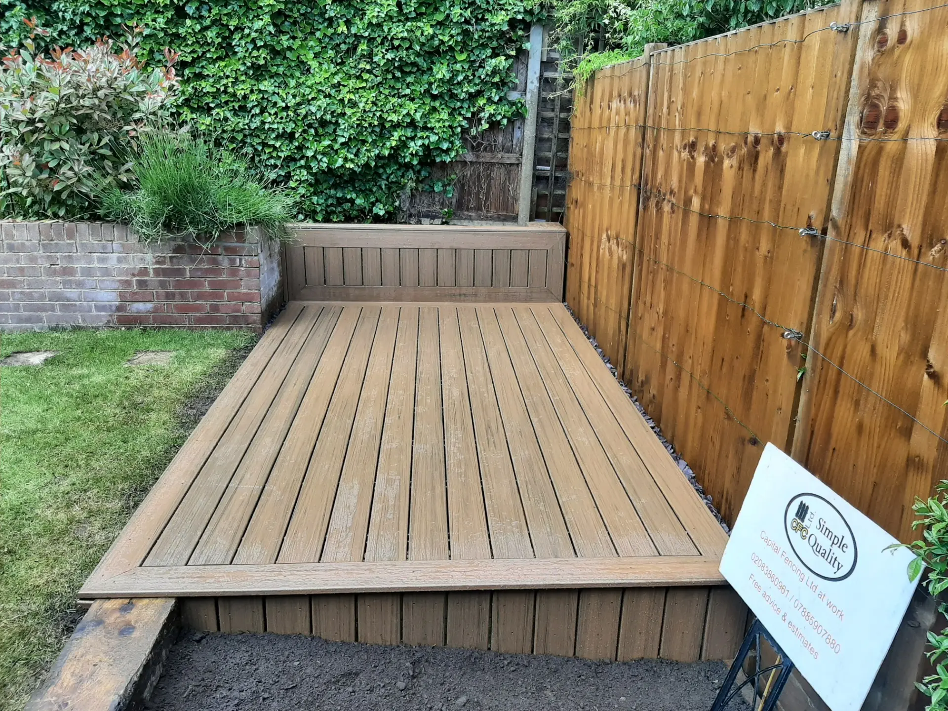 Composite decking laid with a gravel drainage margin against the fence line