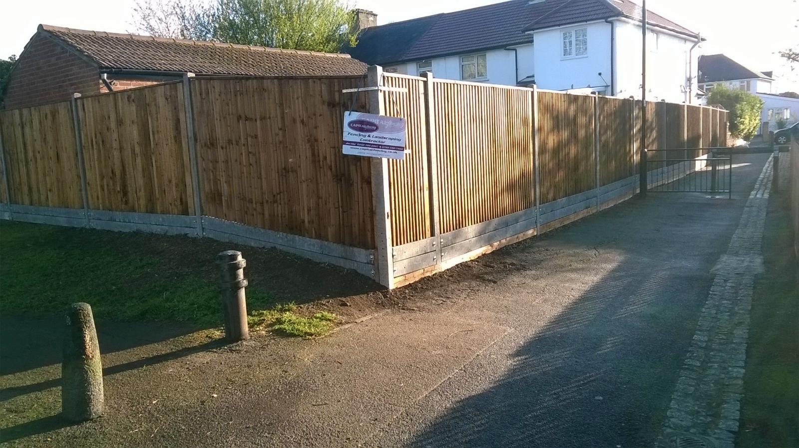 Closeboard fence with tall metal-framed gate